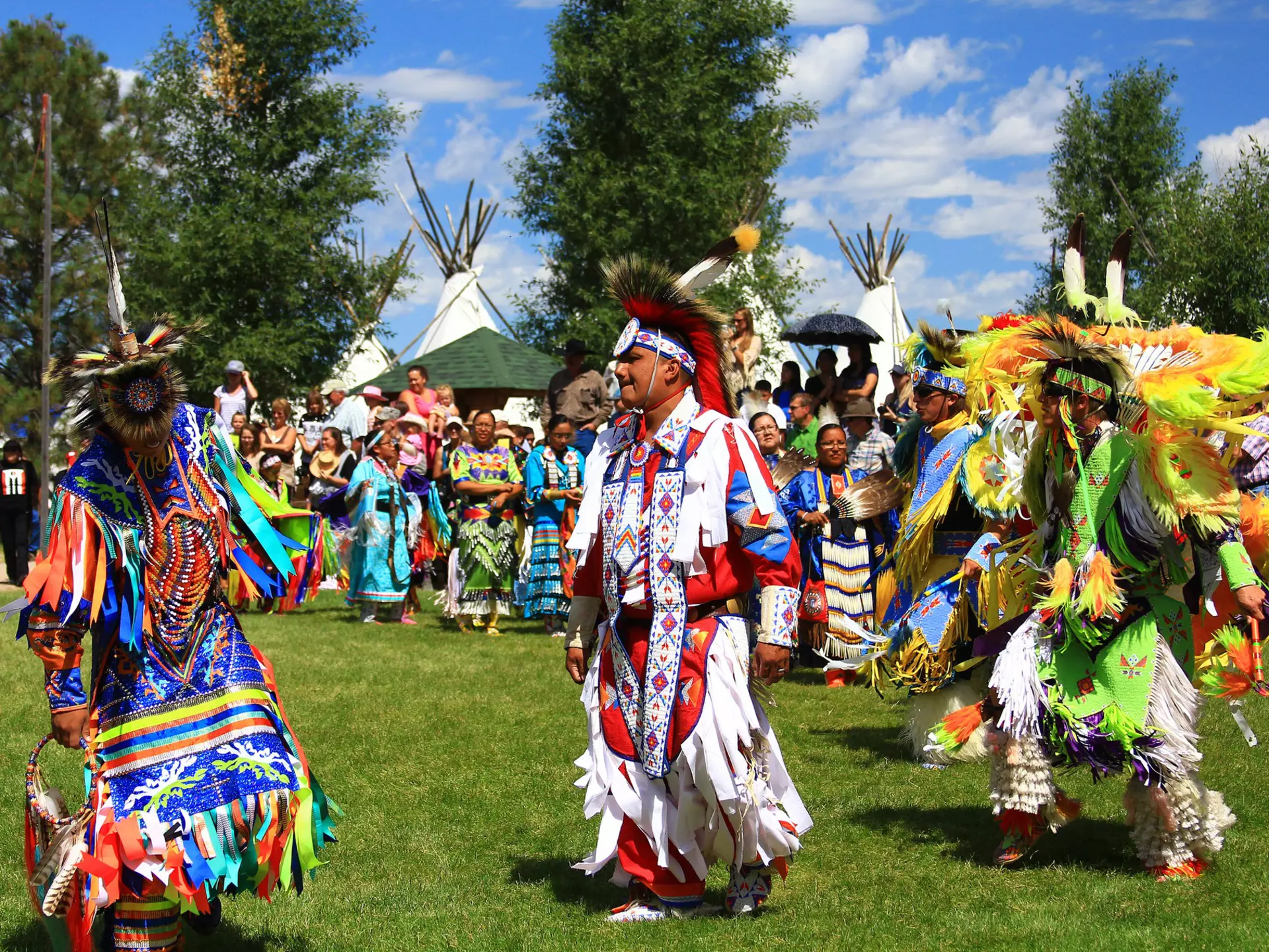 Native American performers in costume dance at a pow-wow.