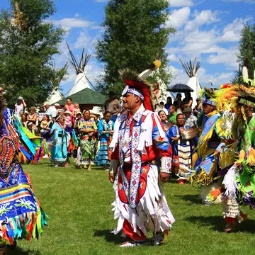 Native American performers in costume dance at a pow-wow.