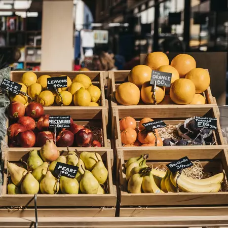 Fresh fruits in wooden crates on sale at Spitalfields Market, one of the finest surviving Victorian Market Halls in London with fashion, antiques and food stalls.