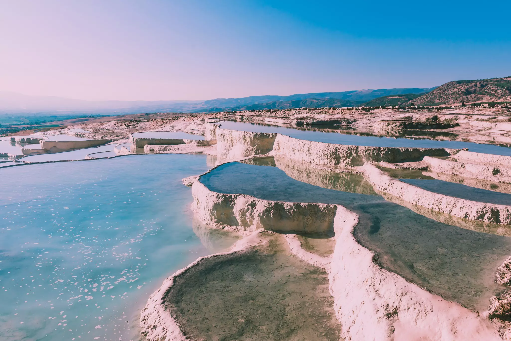 The water-filled terraces of Pamukkale with mountains in the background