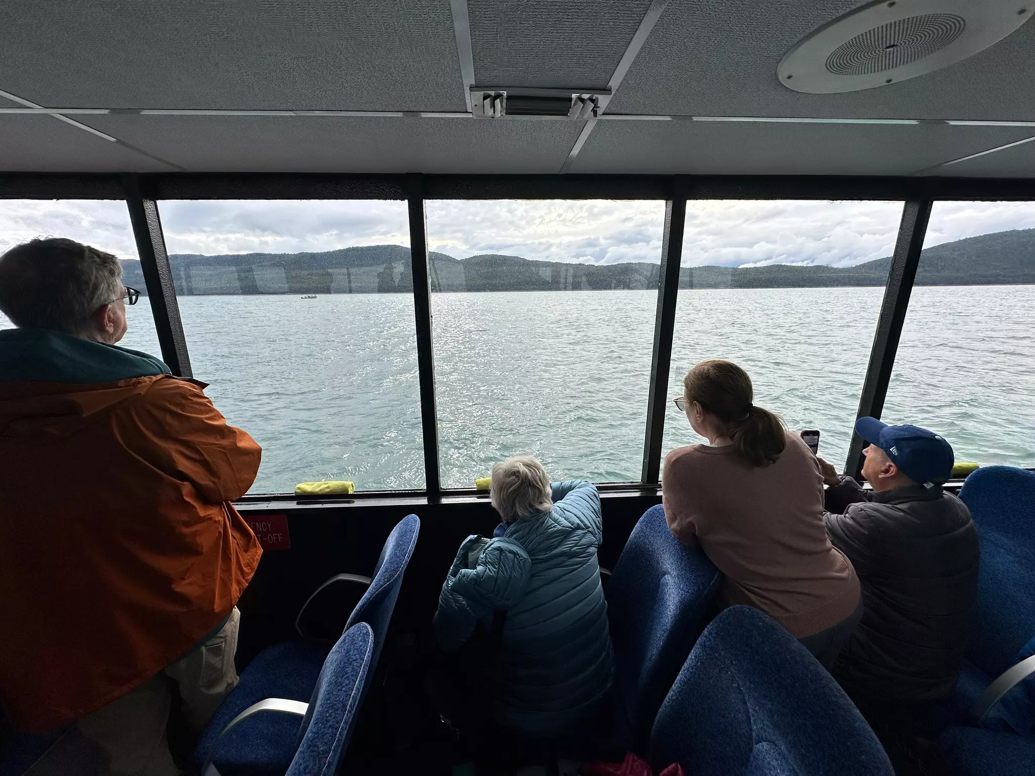 A family inside a cruise ships watching for whales out the ship windows.