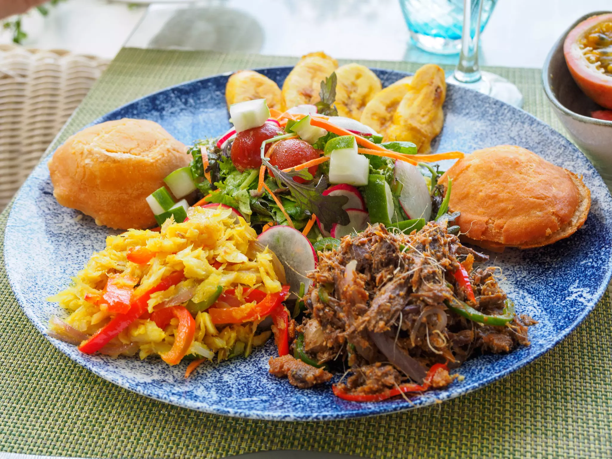 A close-in shot of a plate heaped with plantains, meats, vegetables and other West Indian foods.