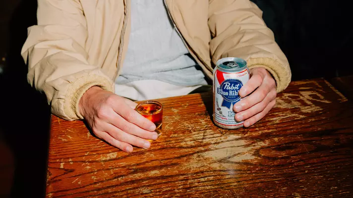 Friends gather on leather sofas at a bar in Manhattan