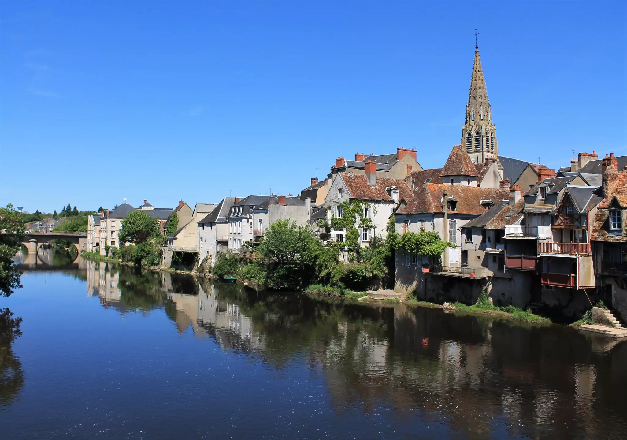 The riverside town of Argenton-sur-Creuse in France, with a tall church steeple dominating the skyline
