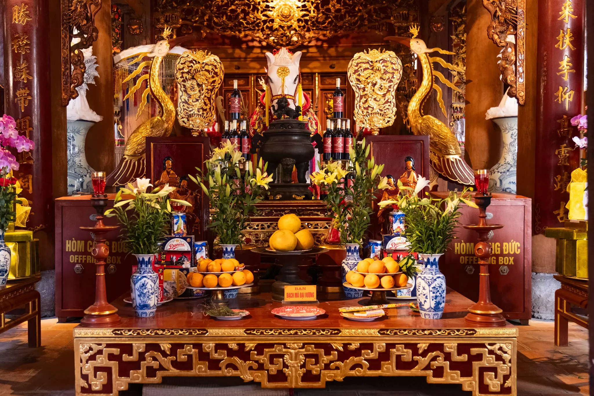 Altar in Bach Ma Temple, Hanoi, with fruit, flowers and other offerings