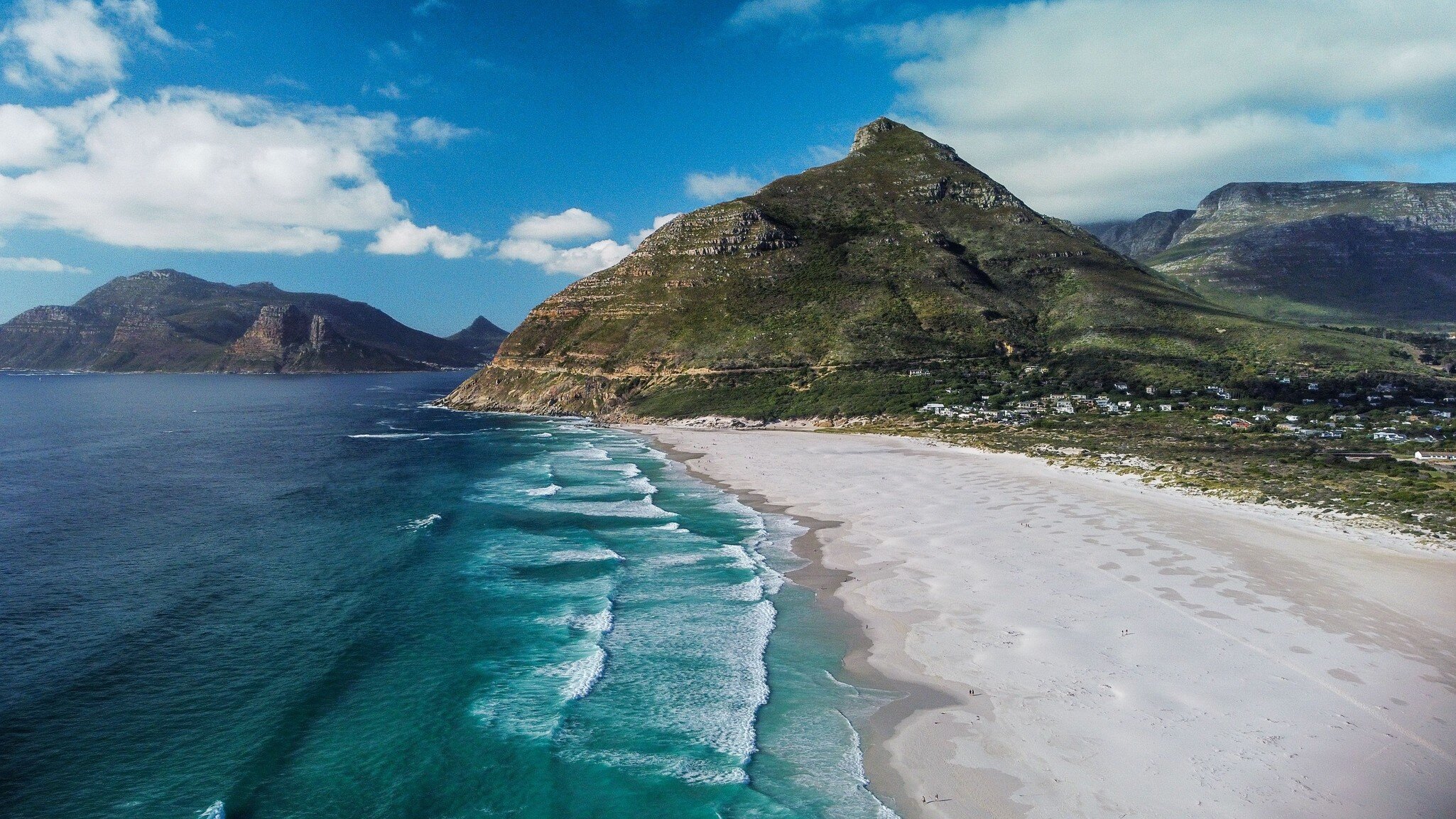 An aerial view of the beautiful Noordhoek Beach and Chapmans Peak in South Africa during summer