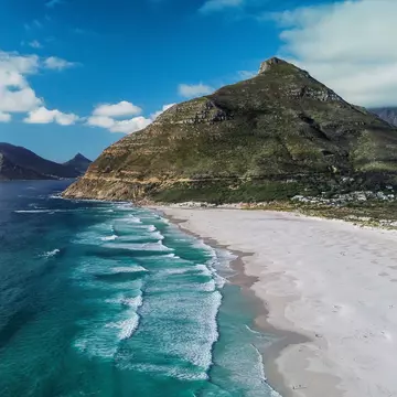 An aerial view of the beautiful Noordhoek Beach and Chapmans Peak in South Africa during summer