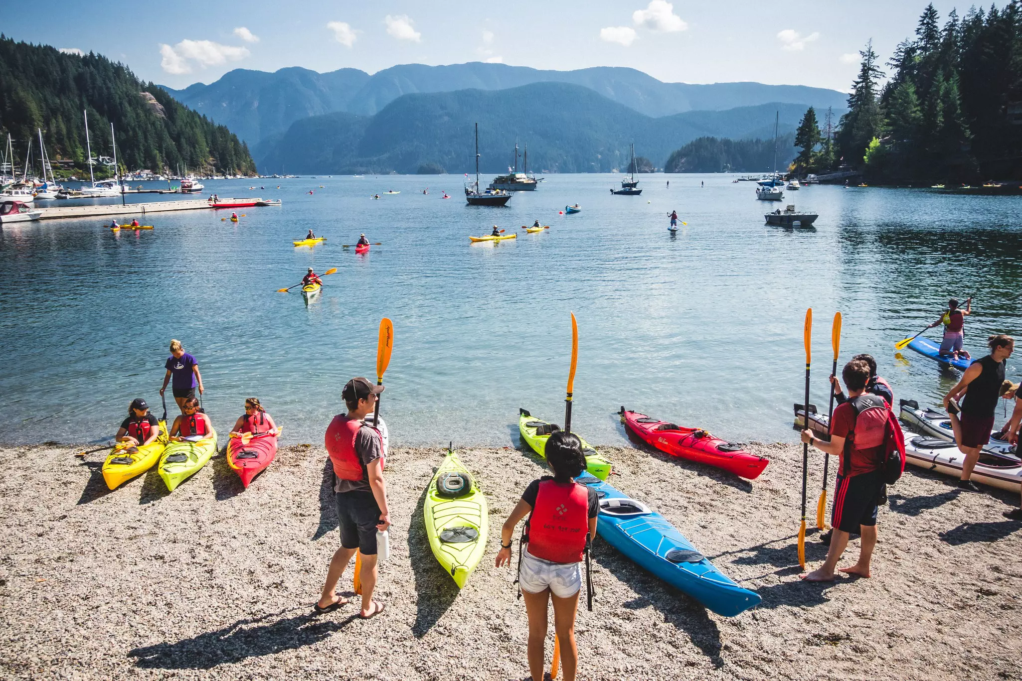 A group of people prepare to enter the water in kayaks.