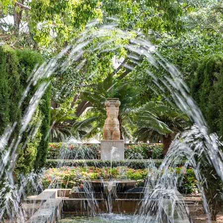 Fountain water arches in the lush gardens
