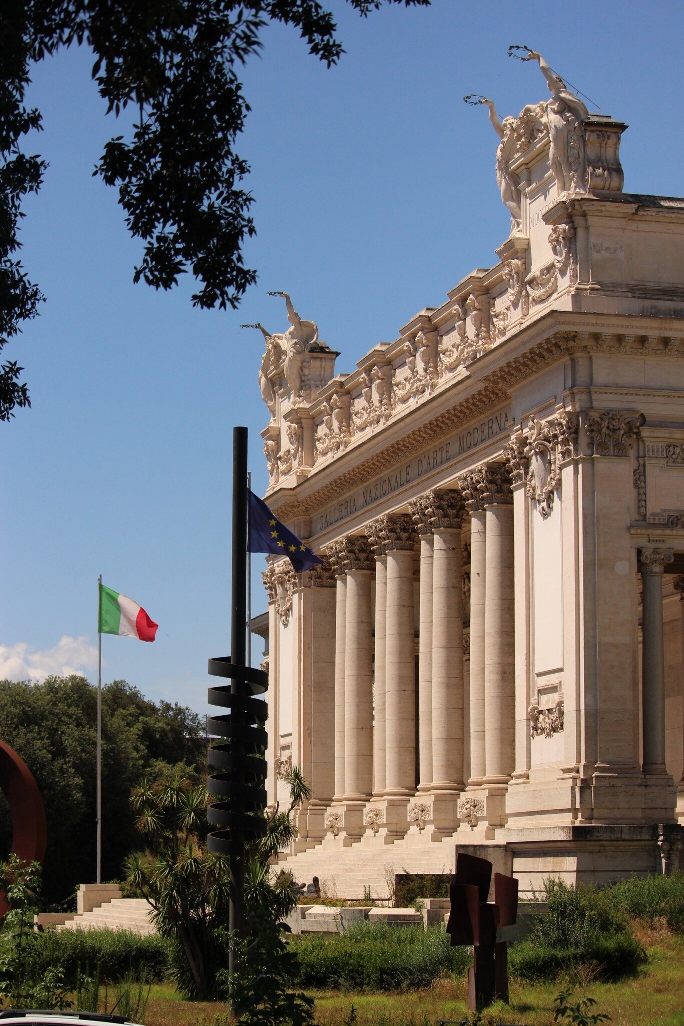 View of La Galleria Nazionale with the European and Italian flags flapping in the foreground in Rome, Italy.