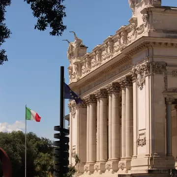 View of La Galleria Nazionale with the European and Italian flags flapping in the foreground in Rome, Italy.