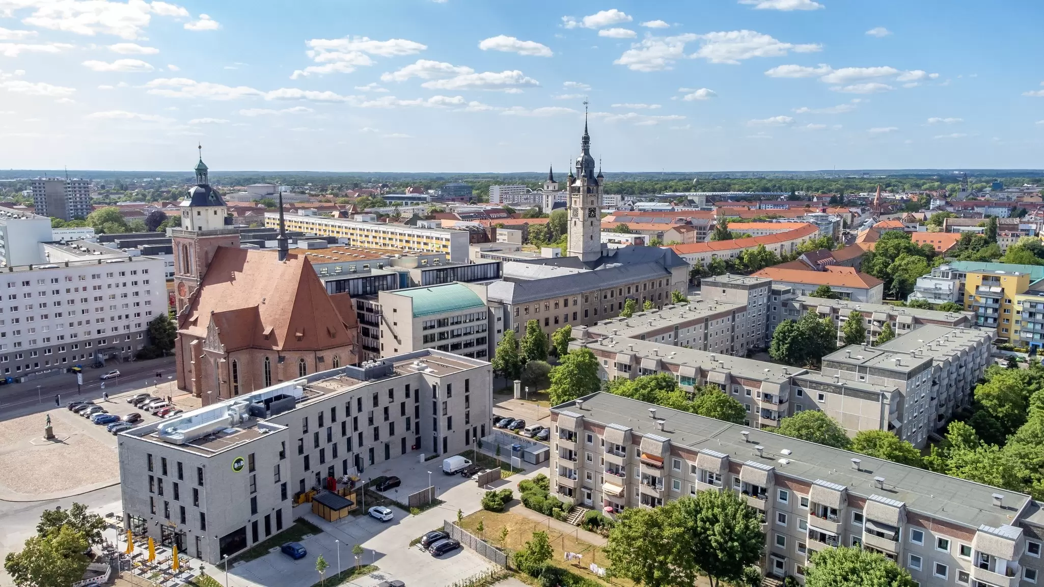 Aerial view of planned housing estates showcasing Bauhaus design in Dessau with a clock tower at the center
