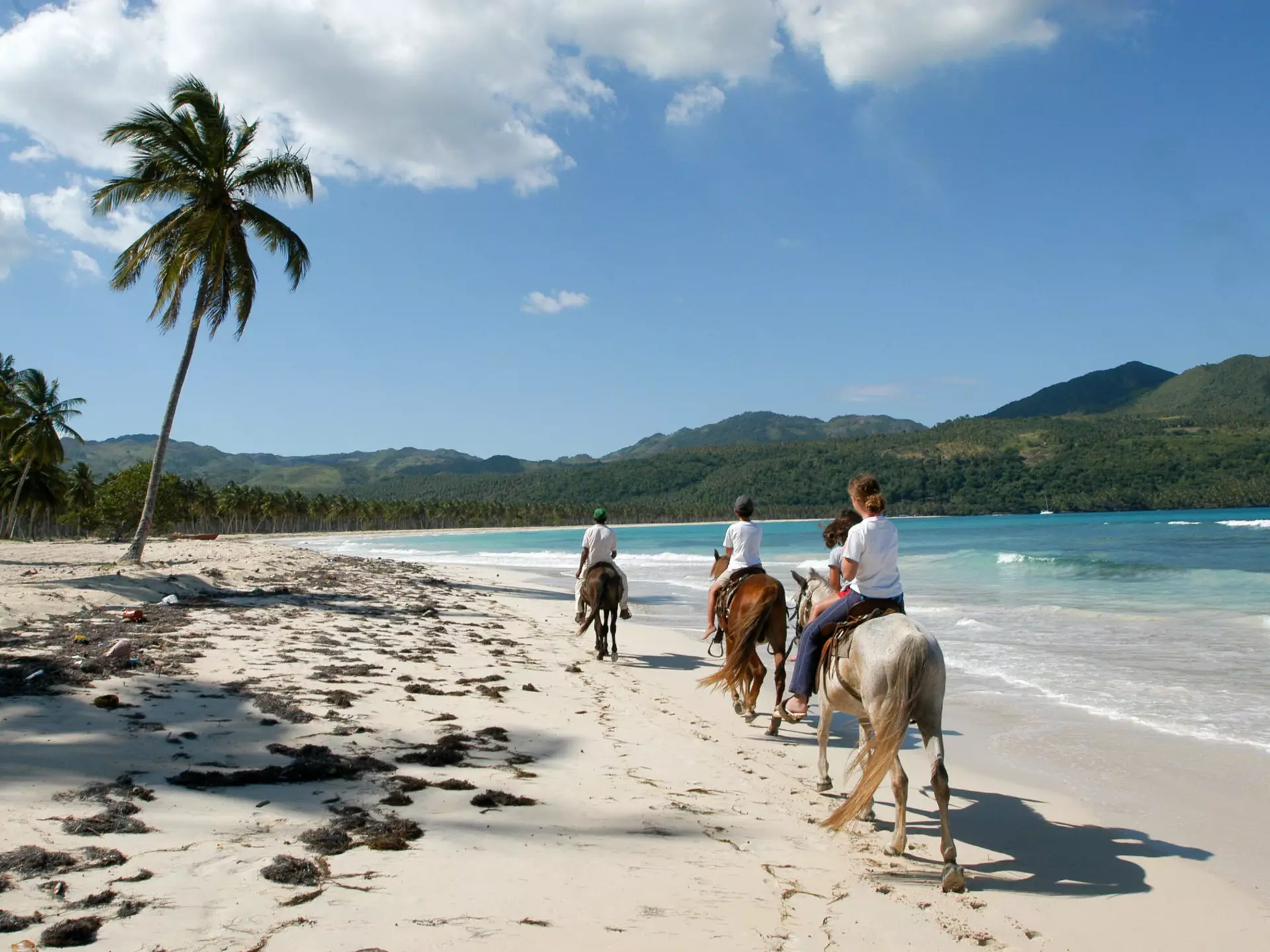 People riding horses on the beach of Rincon near Las Galeras on Dominican Republic.