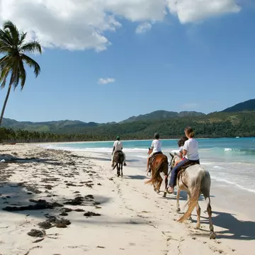 People riding horses on the beach of Rincon near Las Galeras on Dominican Republic.