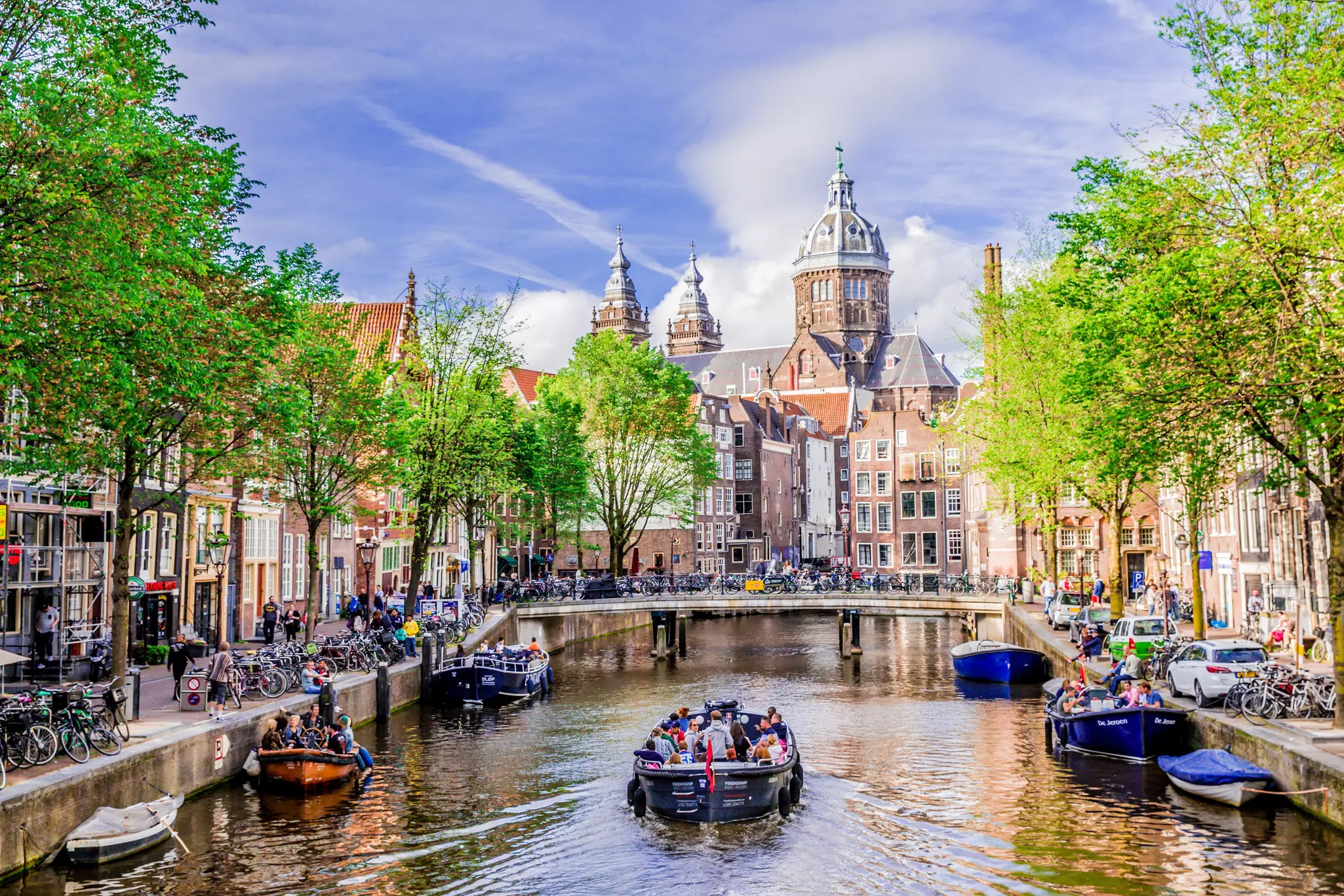 Tour boats on a Dutch canal on a sunny day in Amsterdam