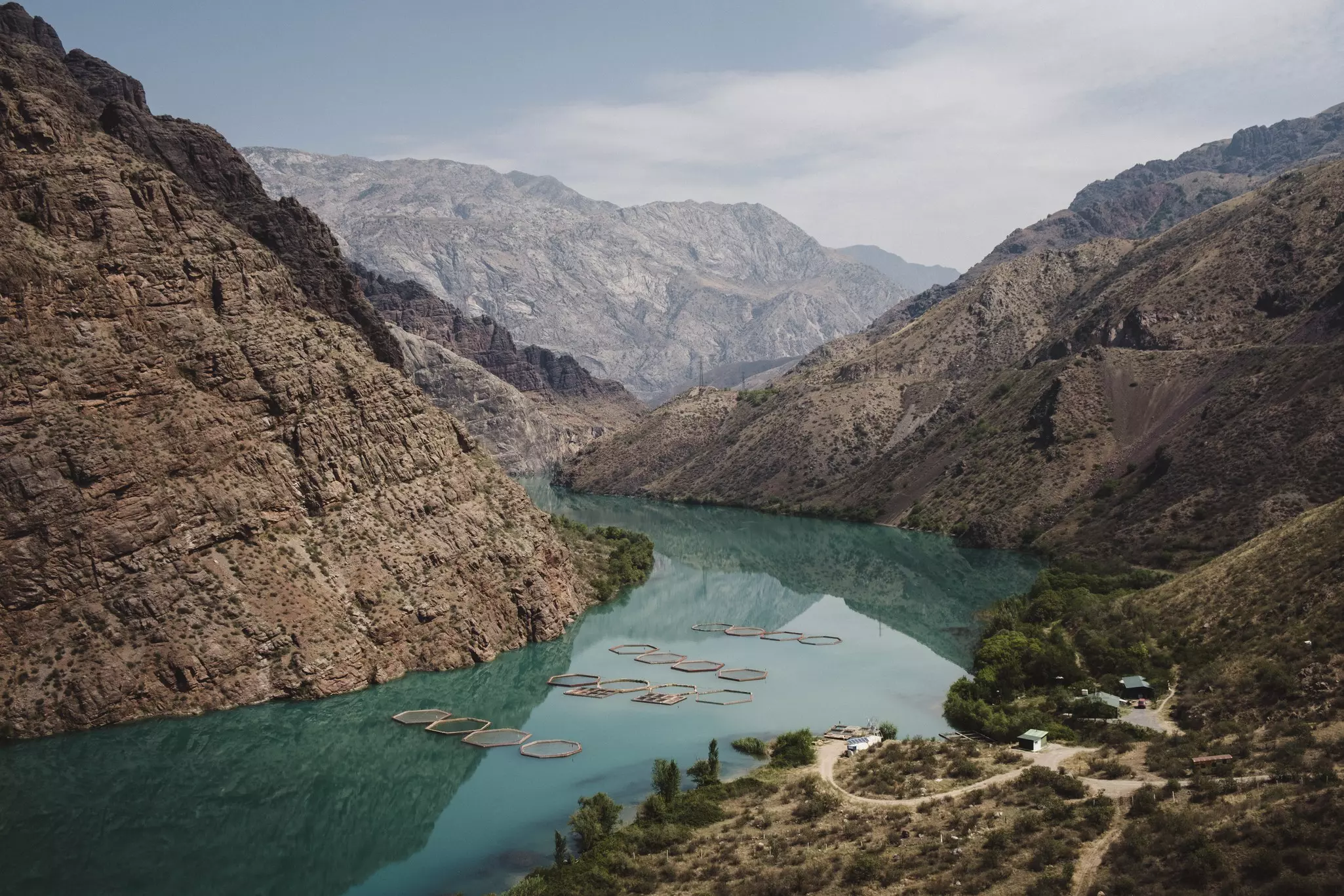 A blue river with mountains and trees surrounding it