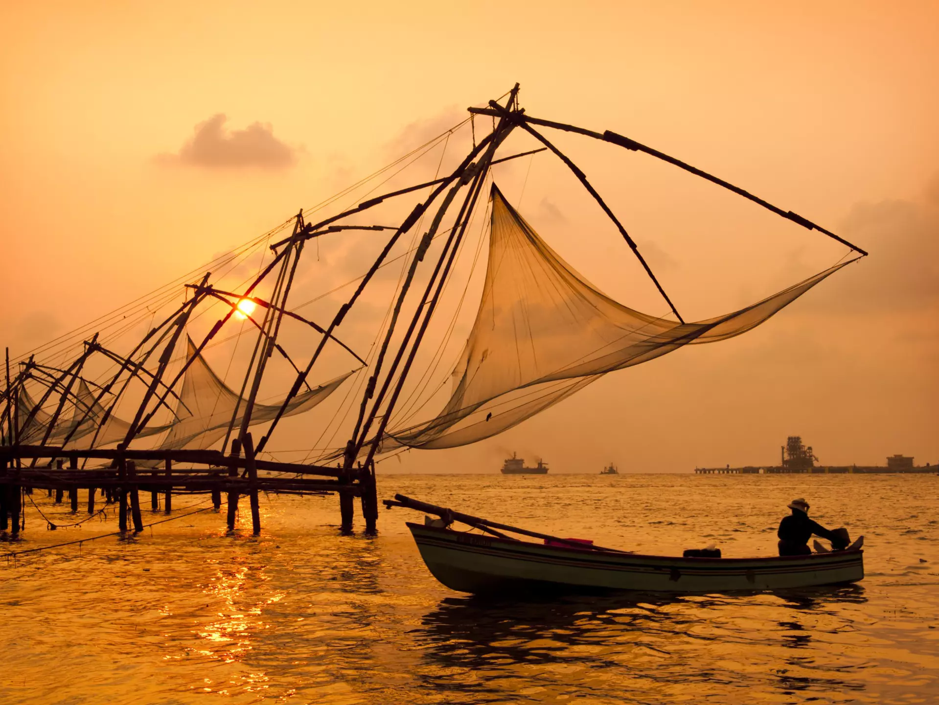 Sunset over Chinese Fishing nets and boat in Cochin (Kochi), Kerala, India.