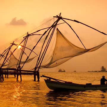 Sunset over Chinese Fishing nets and boat in Cochin (Kochi), Kerala, India.