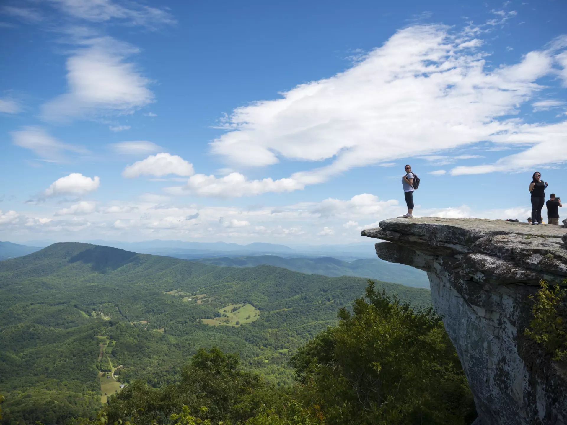 Hikers take in the view of the Appalachian Mountains from McAfee Knob on Catawba Mountain.