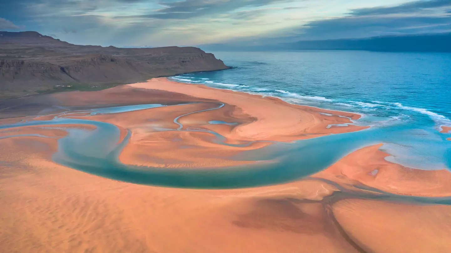 Aerial drone view of icelandic Raudasandur beach with azure water streams and yellow sand