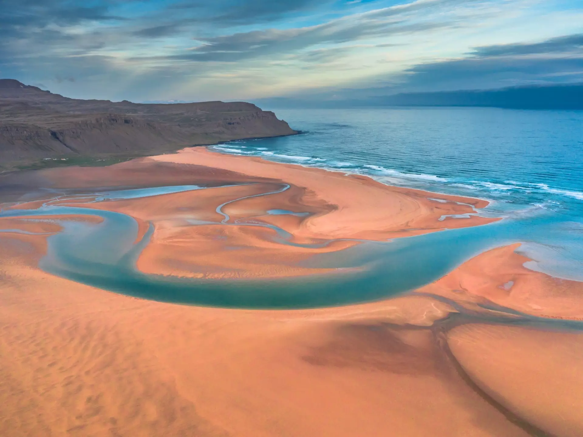 Aerial drone view of icelandic Raudasandur beach with azure water streams and yellow sand