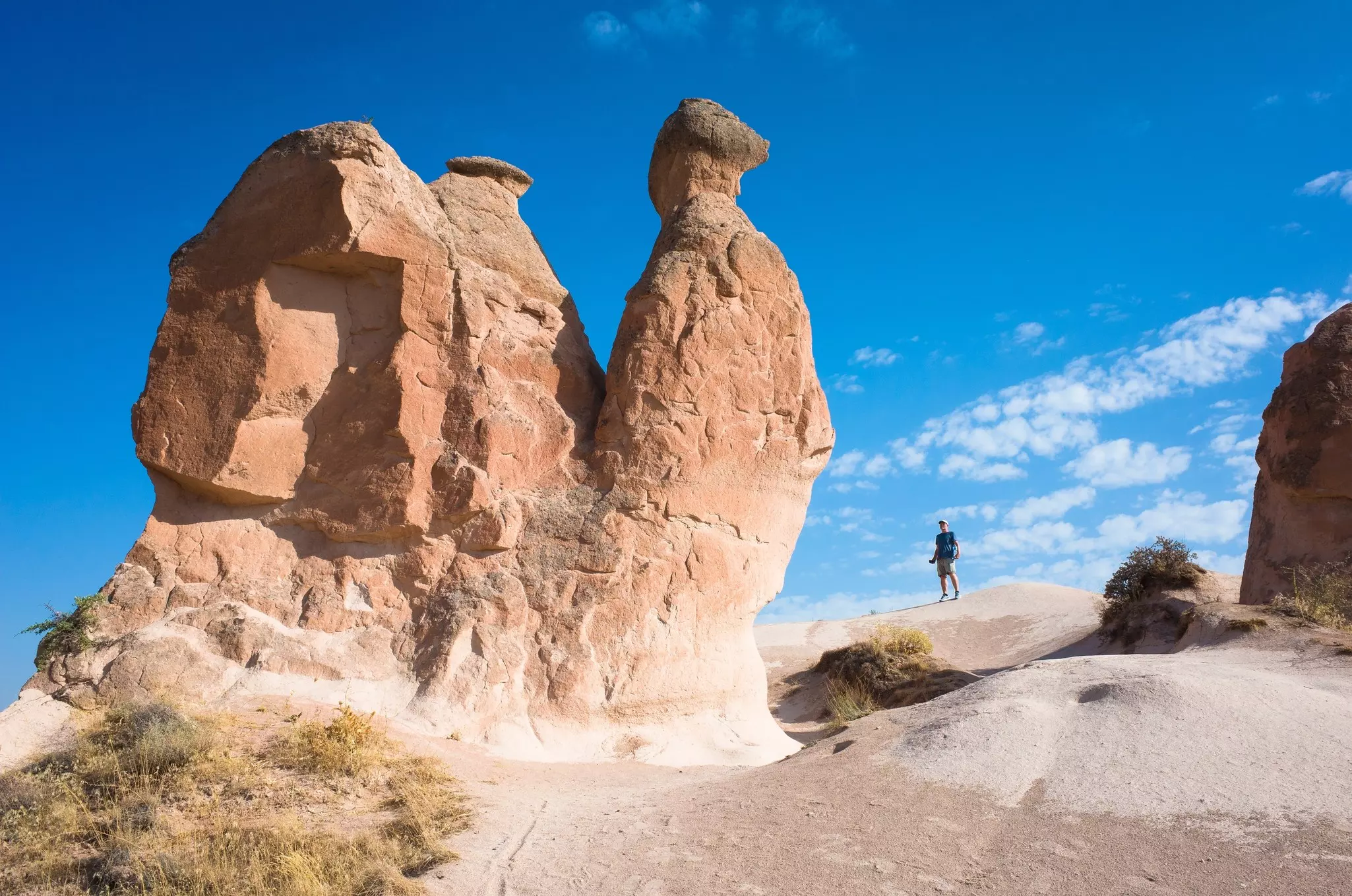 Tourist standing next to famous rock formation in Goreme National Park, Turkey
