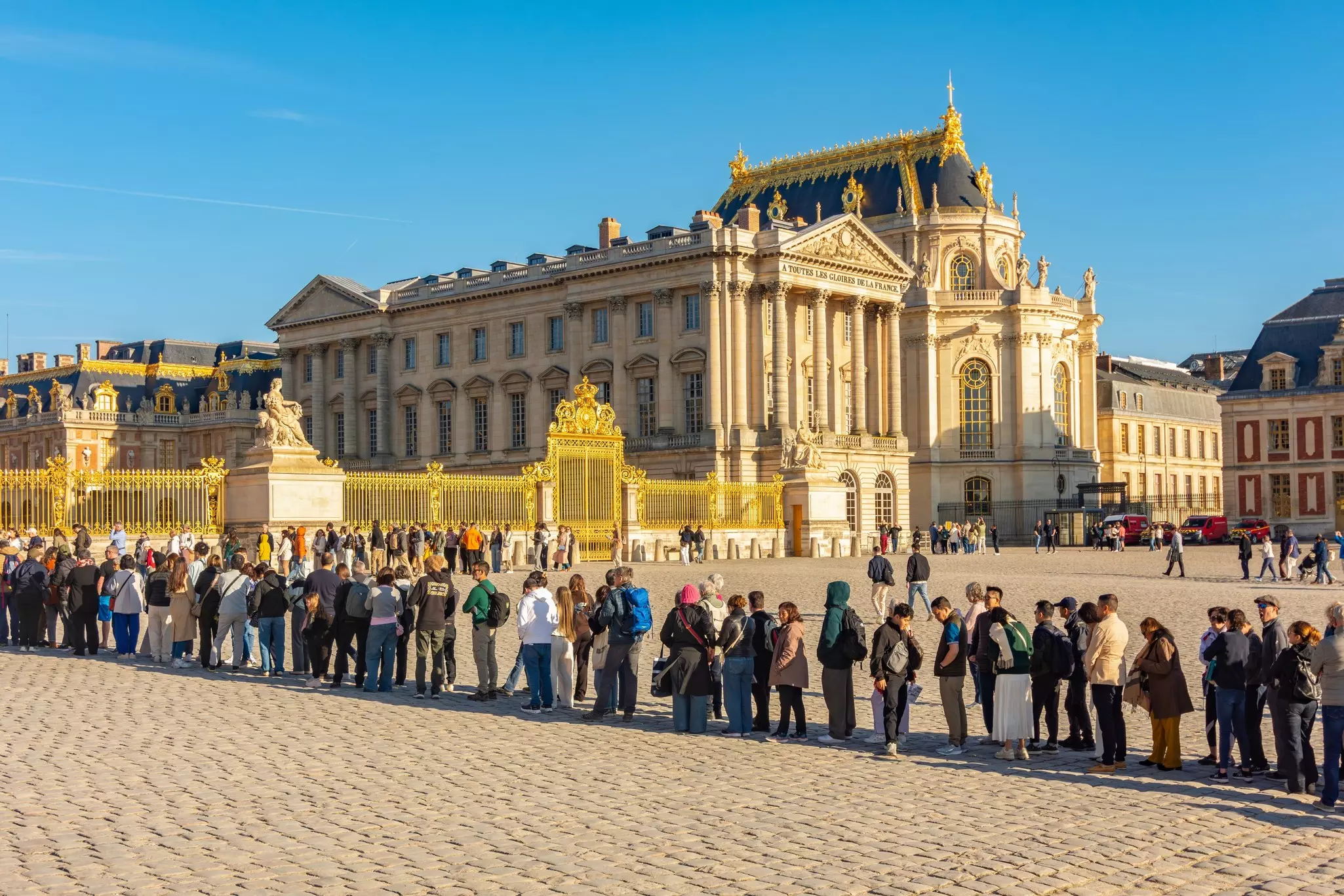 A line of visitors outside a gold gate.