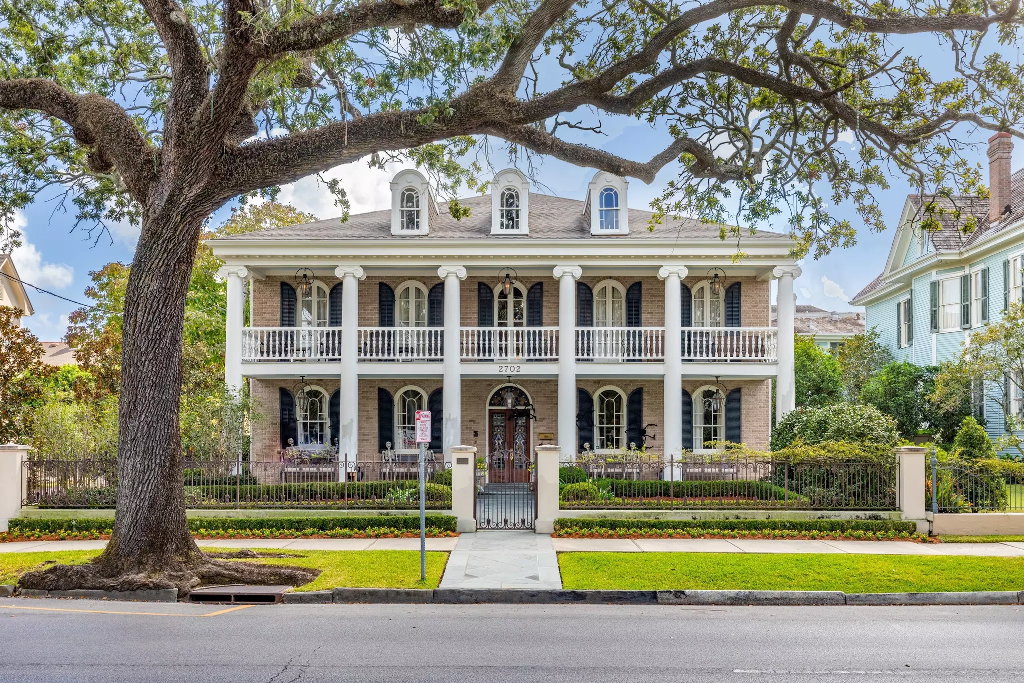A stately home in New Orleans' Garden District with a nicely manicured garden outside.