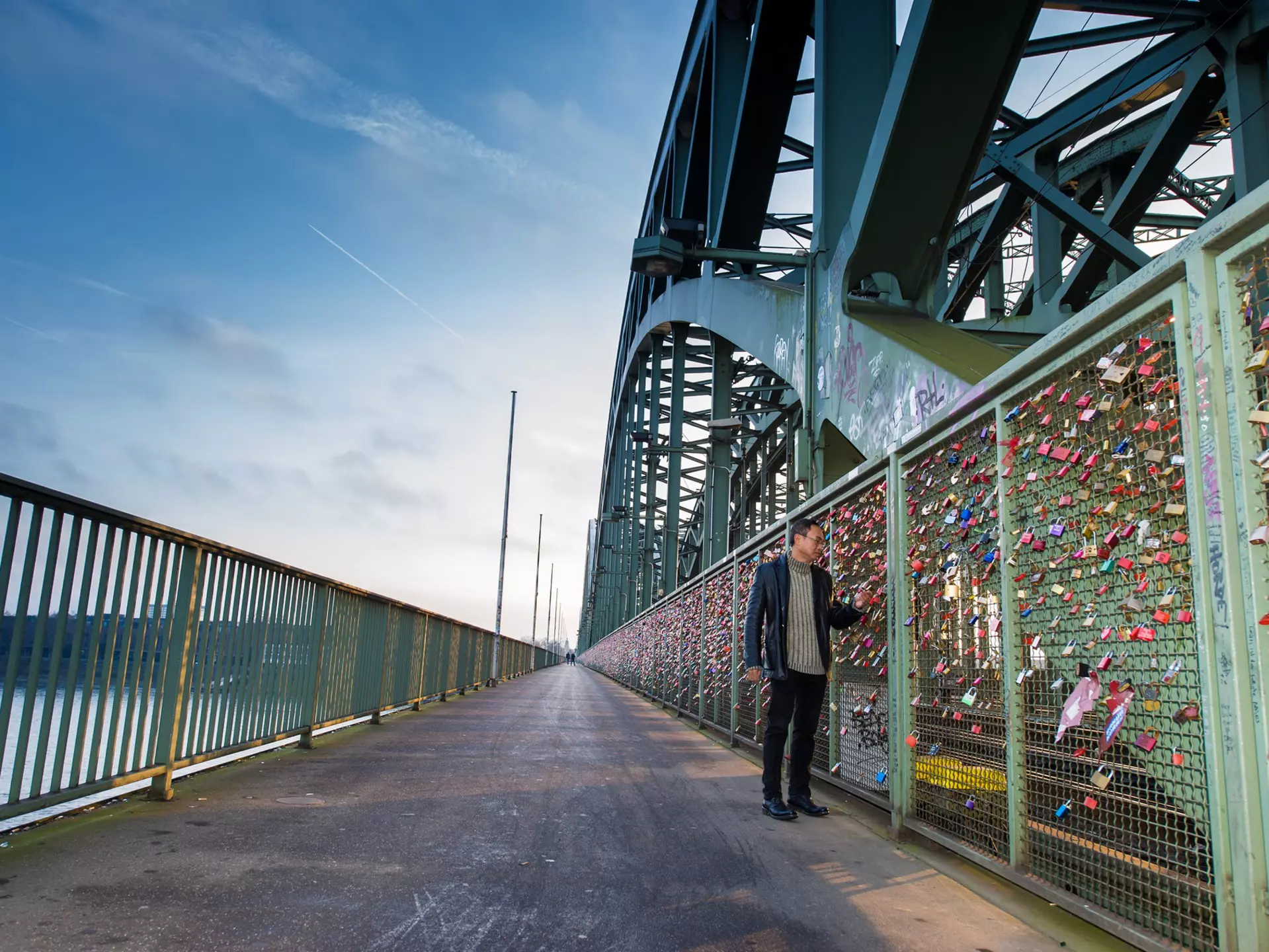 A tourist walking on the Hohenzollern Bridge and looking to the colorful love padlocks in Cologne (Koln), Germany
528287434
love, steel, symbol, friendship, city, germany, isolated, tourism, protection, padlock, colors, hohenzollern, relationships, girders, cologne, lock, perspective, place, make, key, train, footbridge, green, shape, wallpaper, texture, pedestrians, groups, many, declaration, people, names, iron, bridge, travel, fence