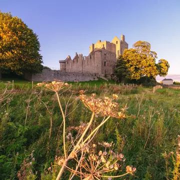 The Craigmillar Castle surrounded by green forestry at sunset, Edinburgh.