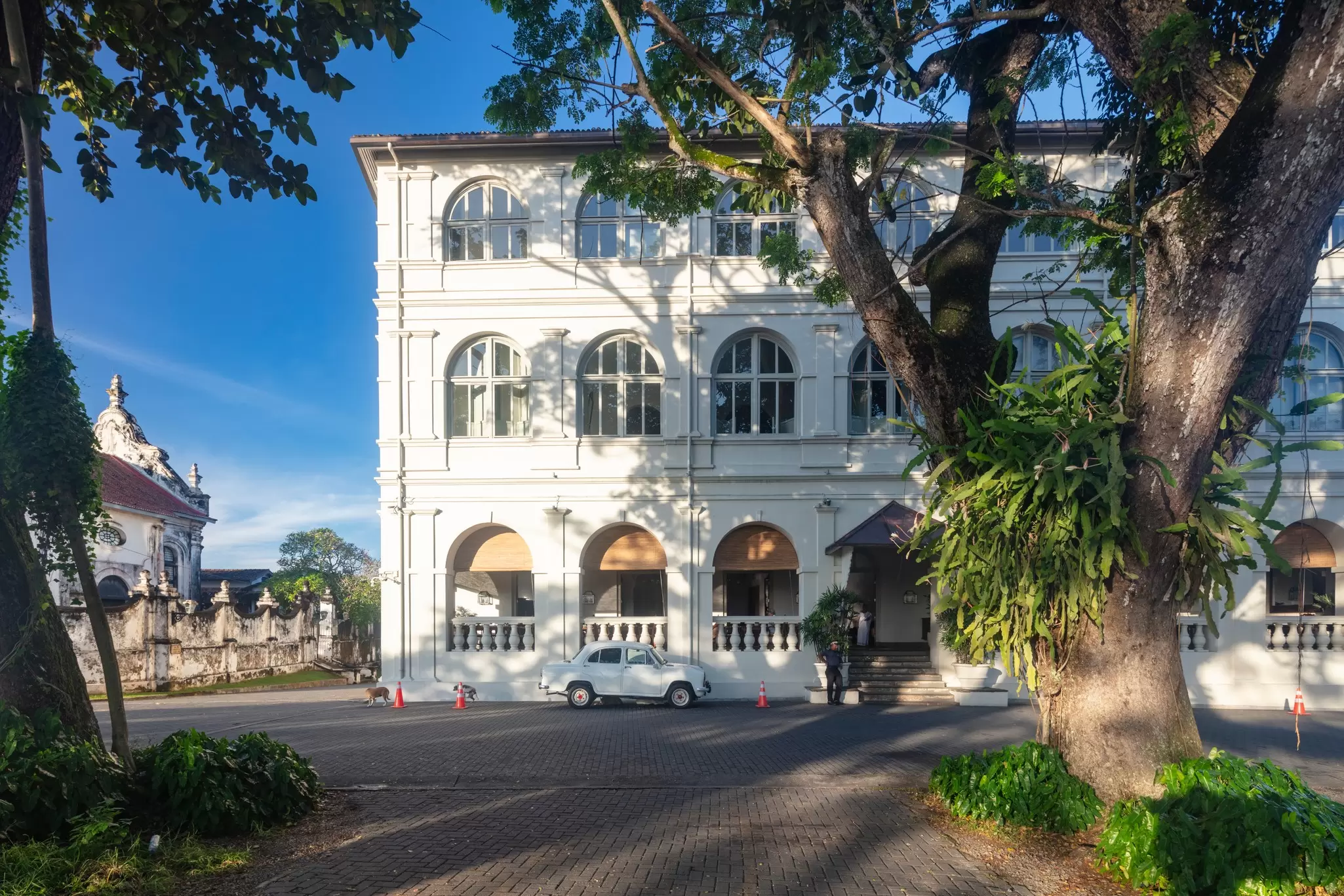 Trees frame the historic Amangalla hotel in the Fort area of Galle, Sri Lanka. 