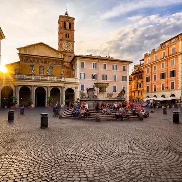 Basilica di Santa Maria and Piazza di Santa Maria in Trastevere during sunset.