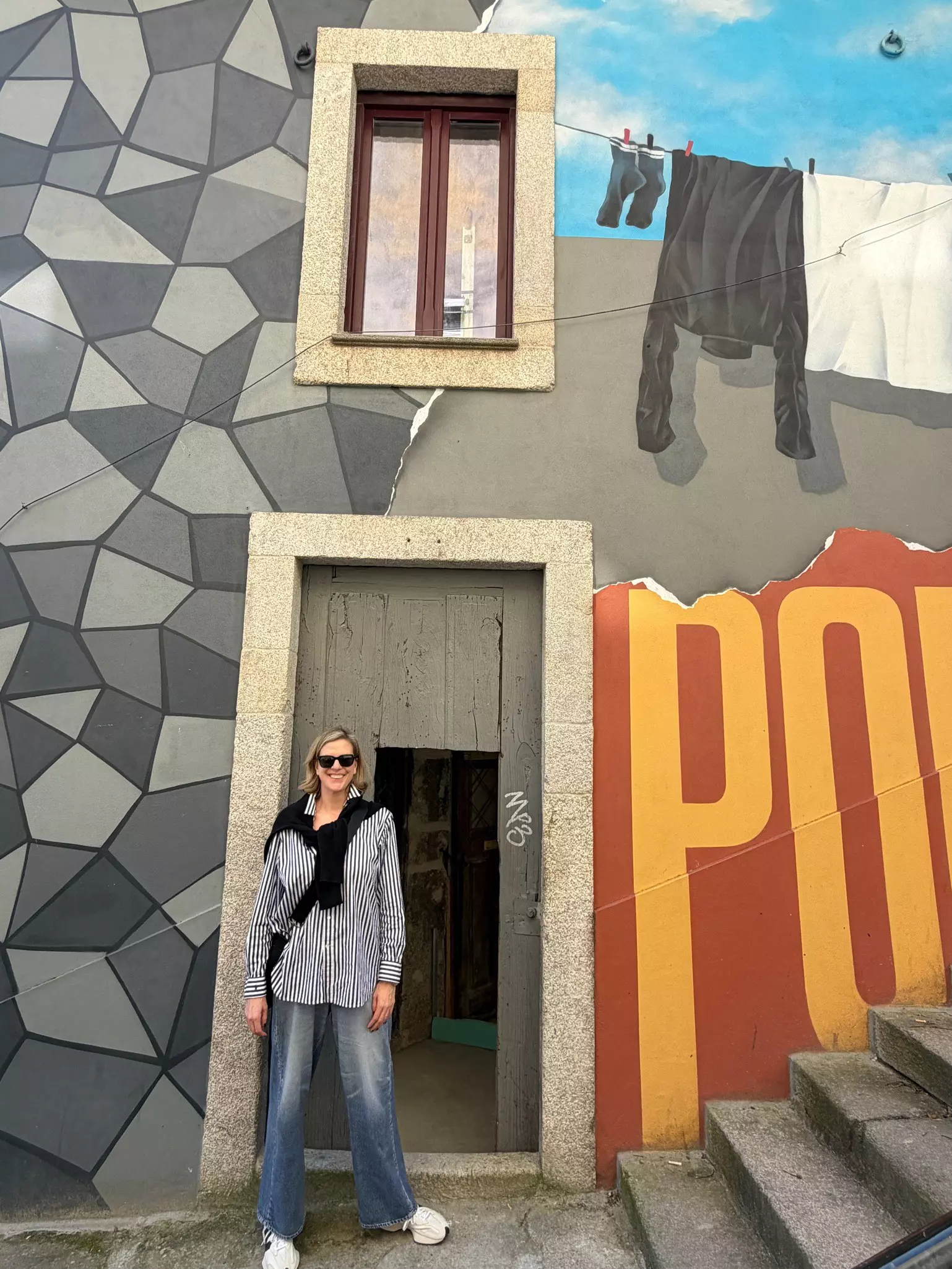 A photo of a woman standing in front of some street art in Porto, Portugal