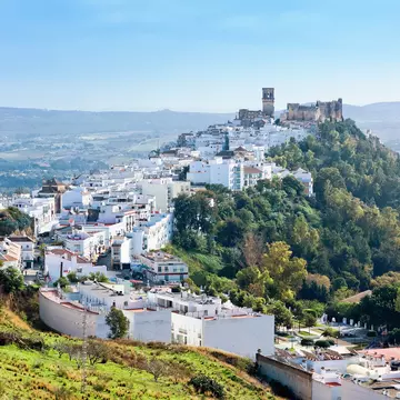 The white buildings of Arcos de la Frontera sit on top of a sandstone ridge.