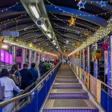 Central, Hong Kong, China, 28 February 2026: people walking along Mid Levels escalator covered walkway decorated with festive lights in busy urban night environment, License Type: media, Download Time: 2026-08-03T19:55:59.000Z, User: LP_KBaxter, Editorial: true, purchase_order: 65050 - Digital Destinations and Articles, job: lonely-planet, client: The Anti-Itinerary: 6 Trips Where Getting Lost Is the Point, other: Kathleen Baxter