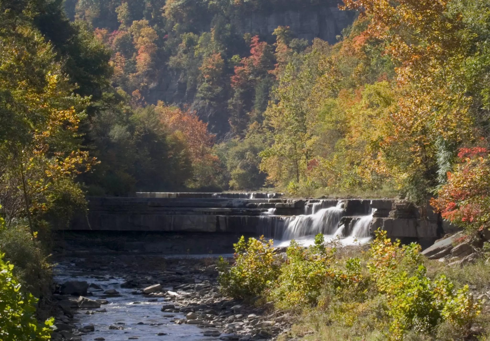 A small waterfall in central New York surrounded by trees in autumn.