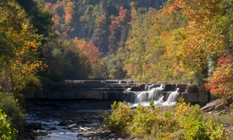 A small waterfall in central New York surrounded by trees in autumn.