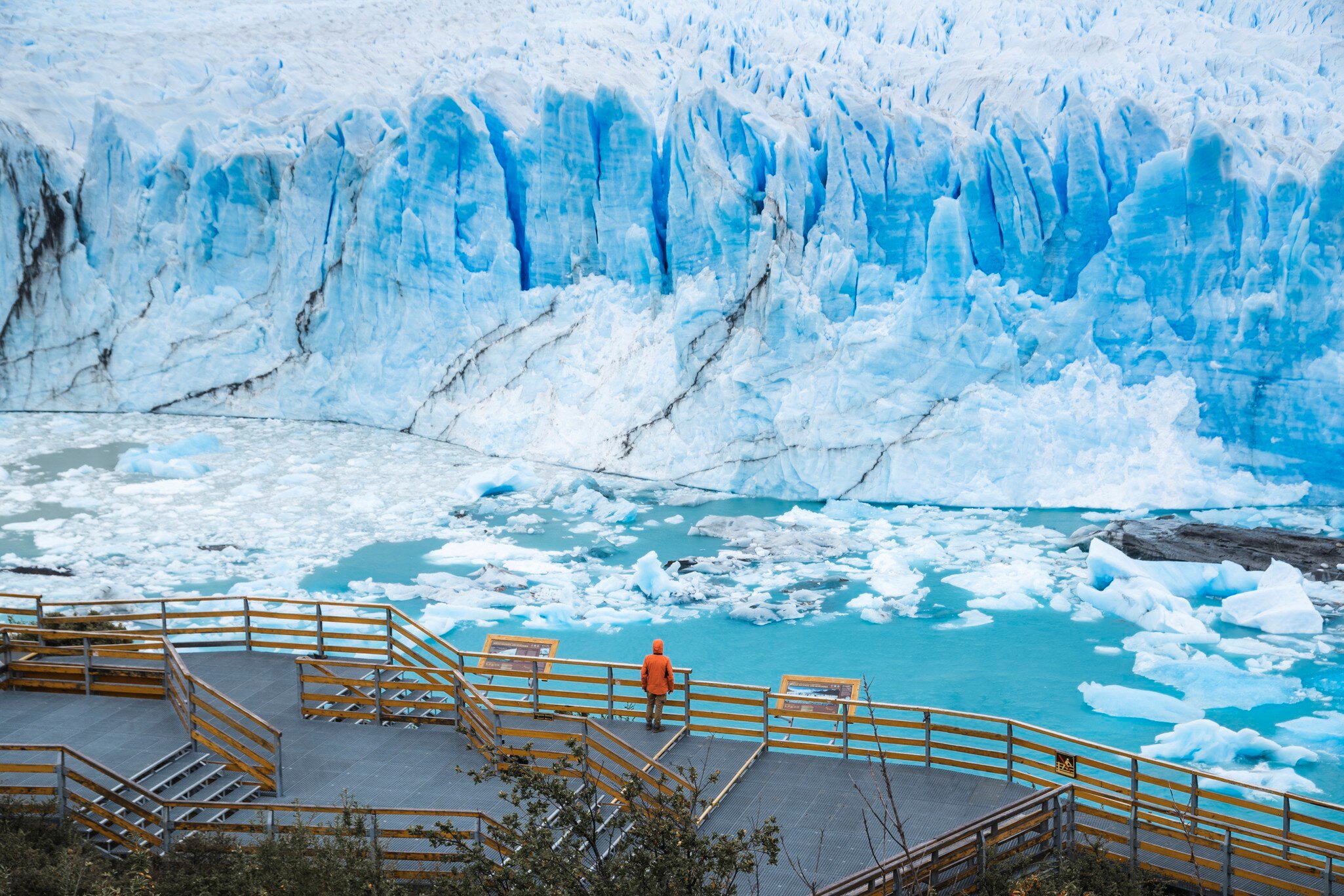 One person standing on the balcony looking out at the Perito Moreno glacier in Patagonia, Argentina.