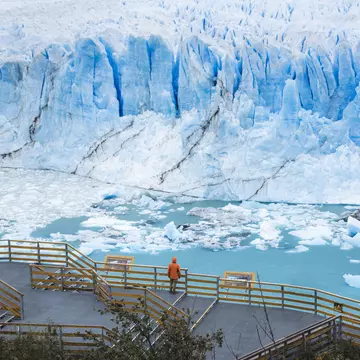 One person standing on the balcony looking out at the Perito Moreno glacier in Patagonia, Argentina.