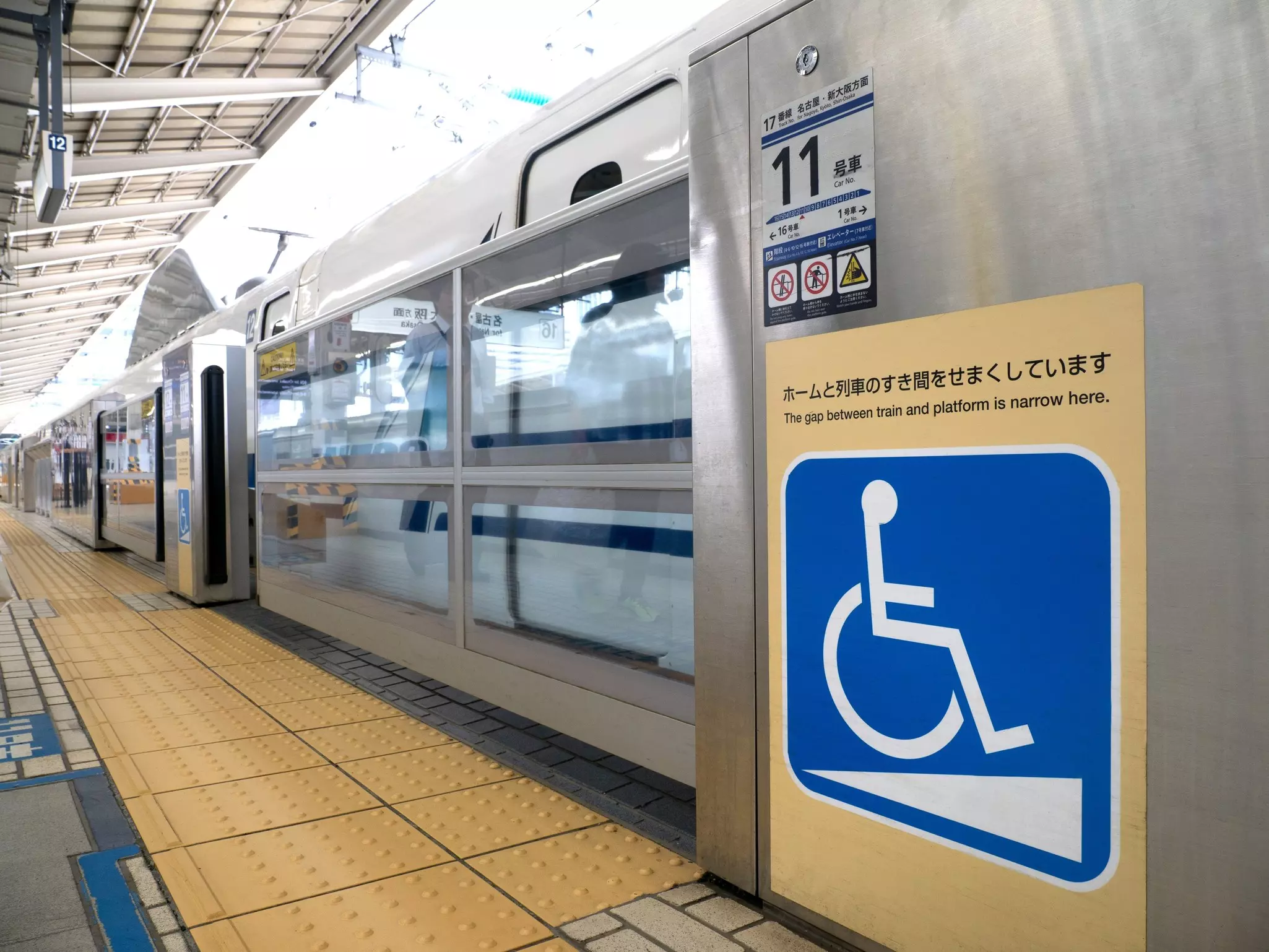 An accessibility sign is seen on a gate in a train station.