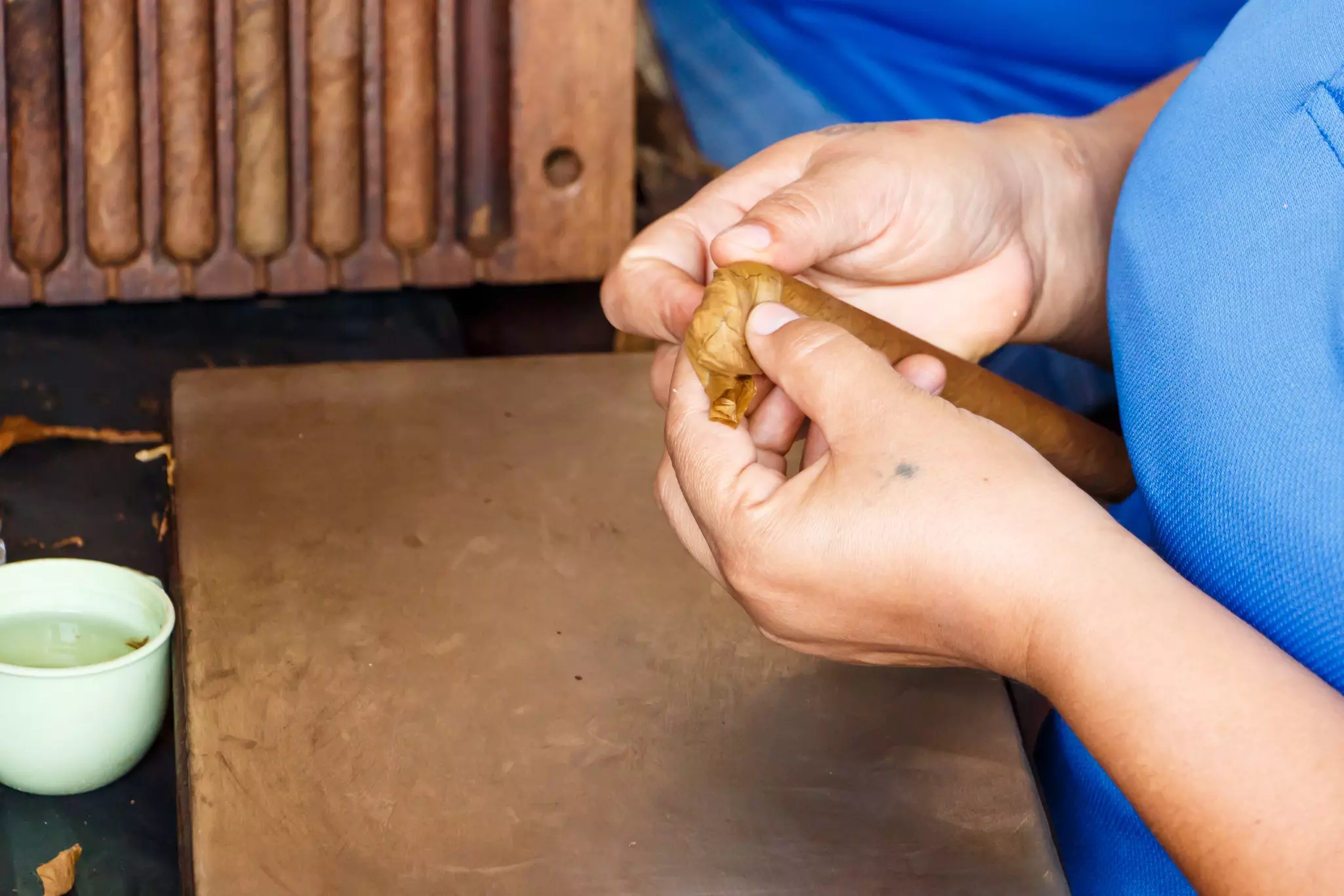 A person making cigars at a cigar factory