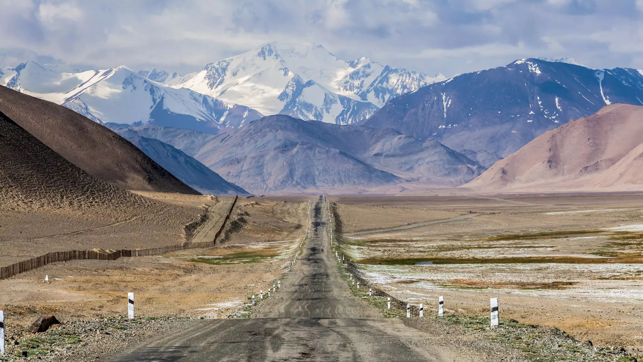Snowy mountains frame the Pamir Highway in Tajikistan.