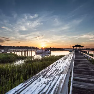 Old wooden dock leading to a beautiful sunrise over the marsh in Savannah, Georgia, Dai Mar Tamarack / Shutterstock
