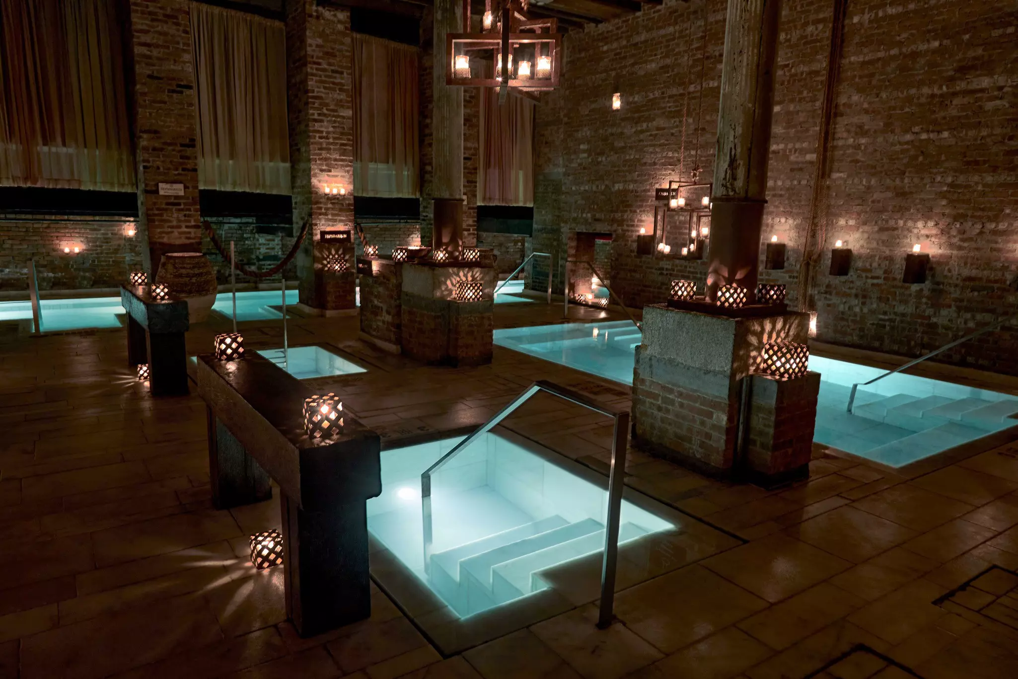 Pools of water in a dark spa room.