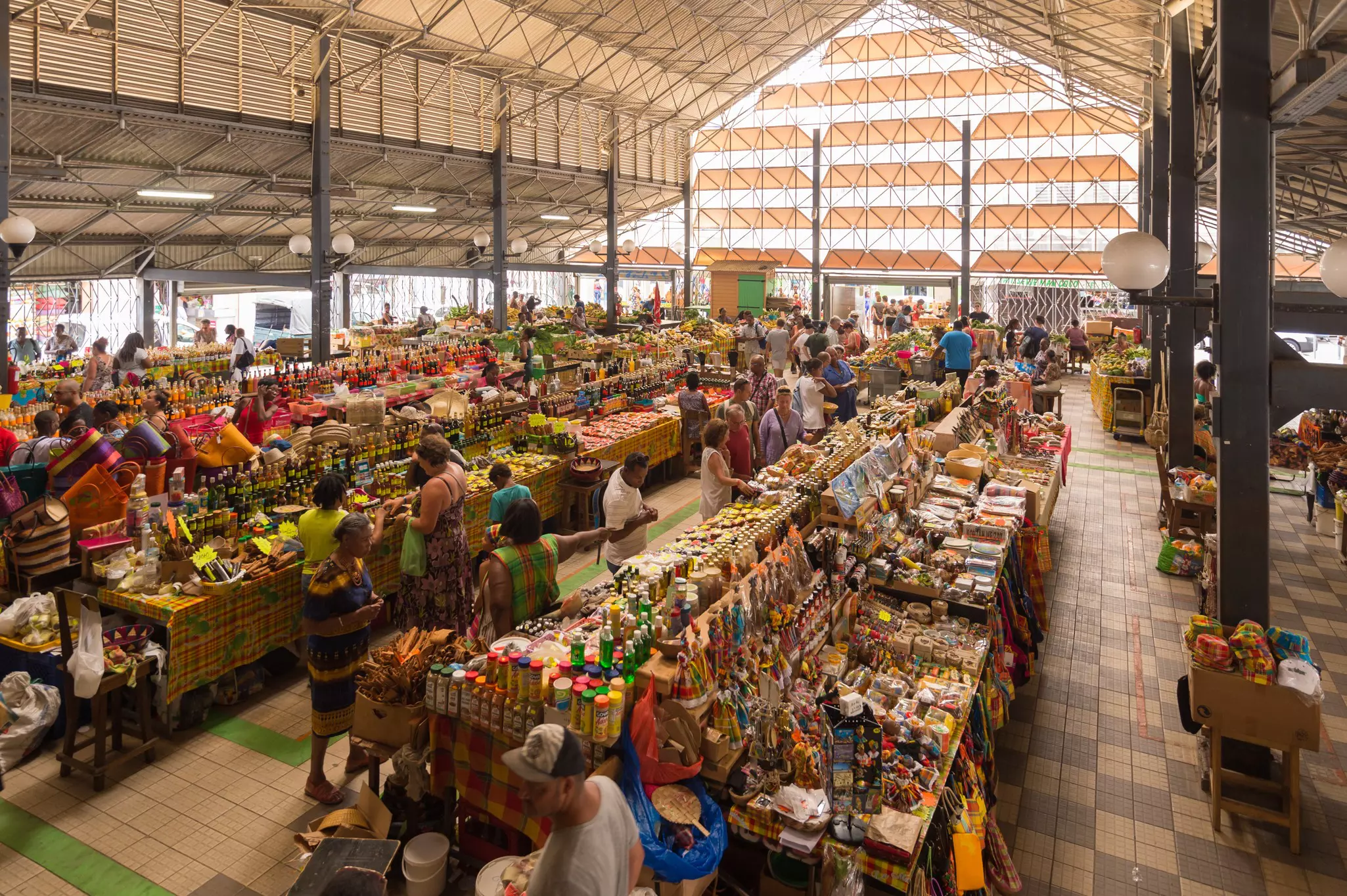 A busy shop floor with vendors selling food, trinkets, souvenirs, gifts in a covered market.