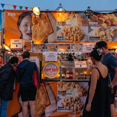 People walking around the local night market in a Chinese neighborhood at twilight in Richmond, British Columbia
