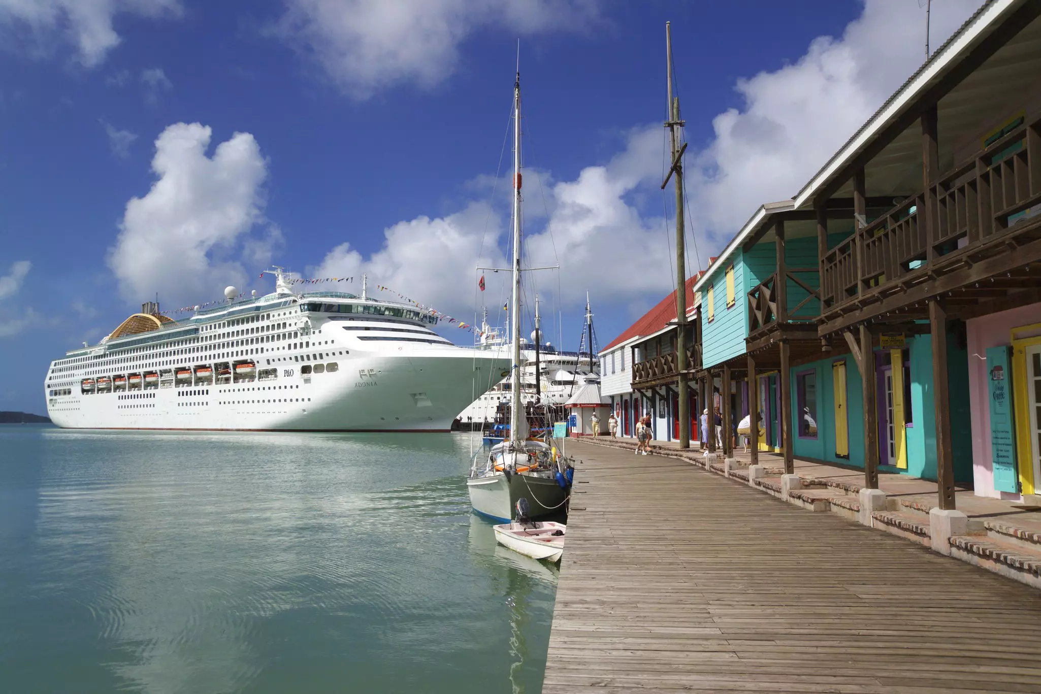 A cruise ship docking at a pier with colorful wooden buildings.