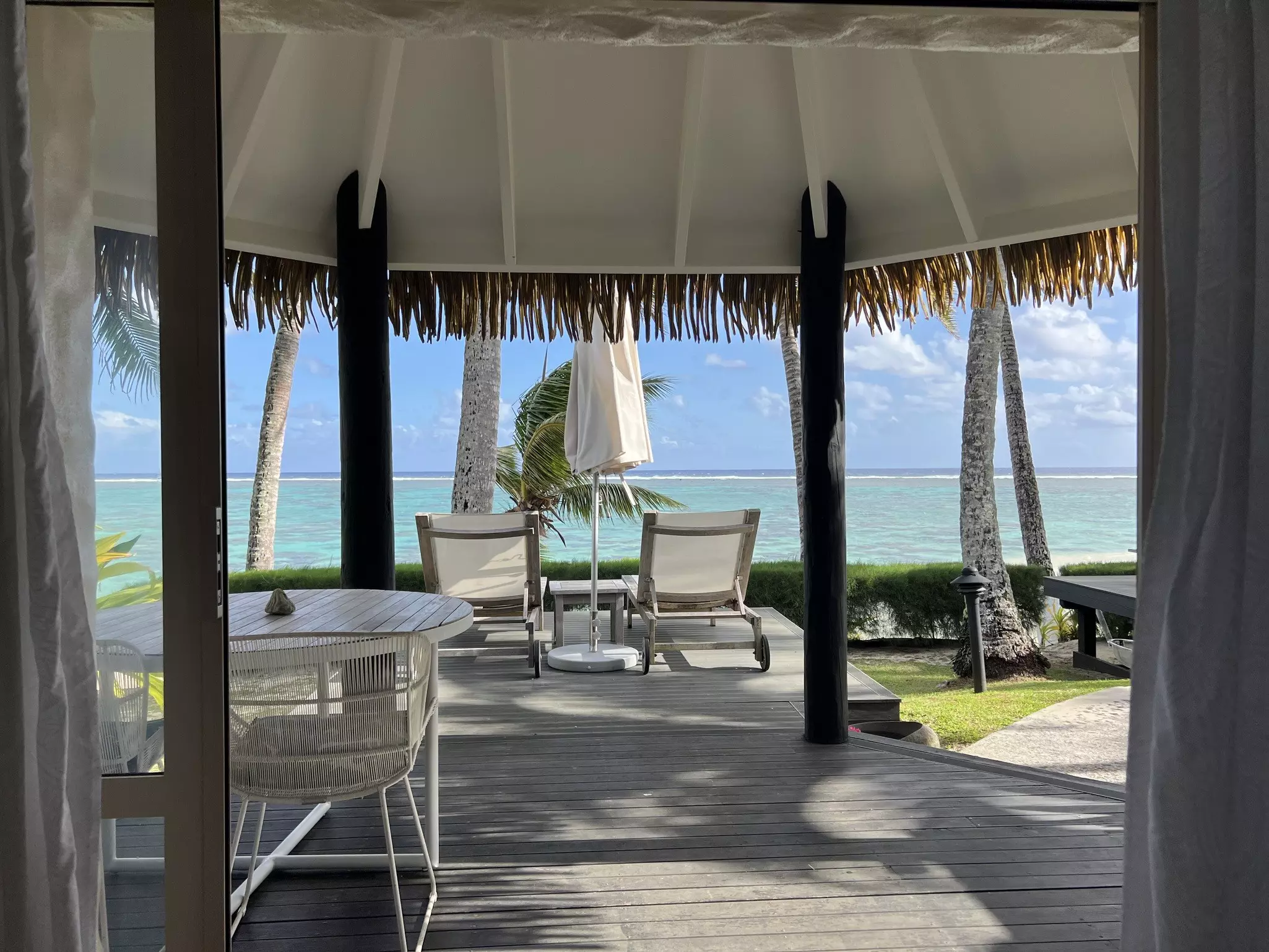 Sunloungers set up under a canopy facing the turquoise lagoon.