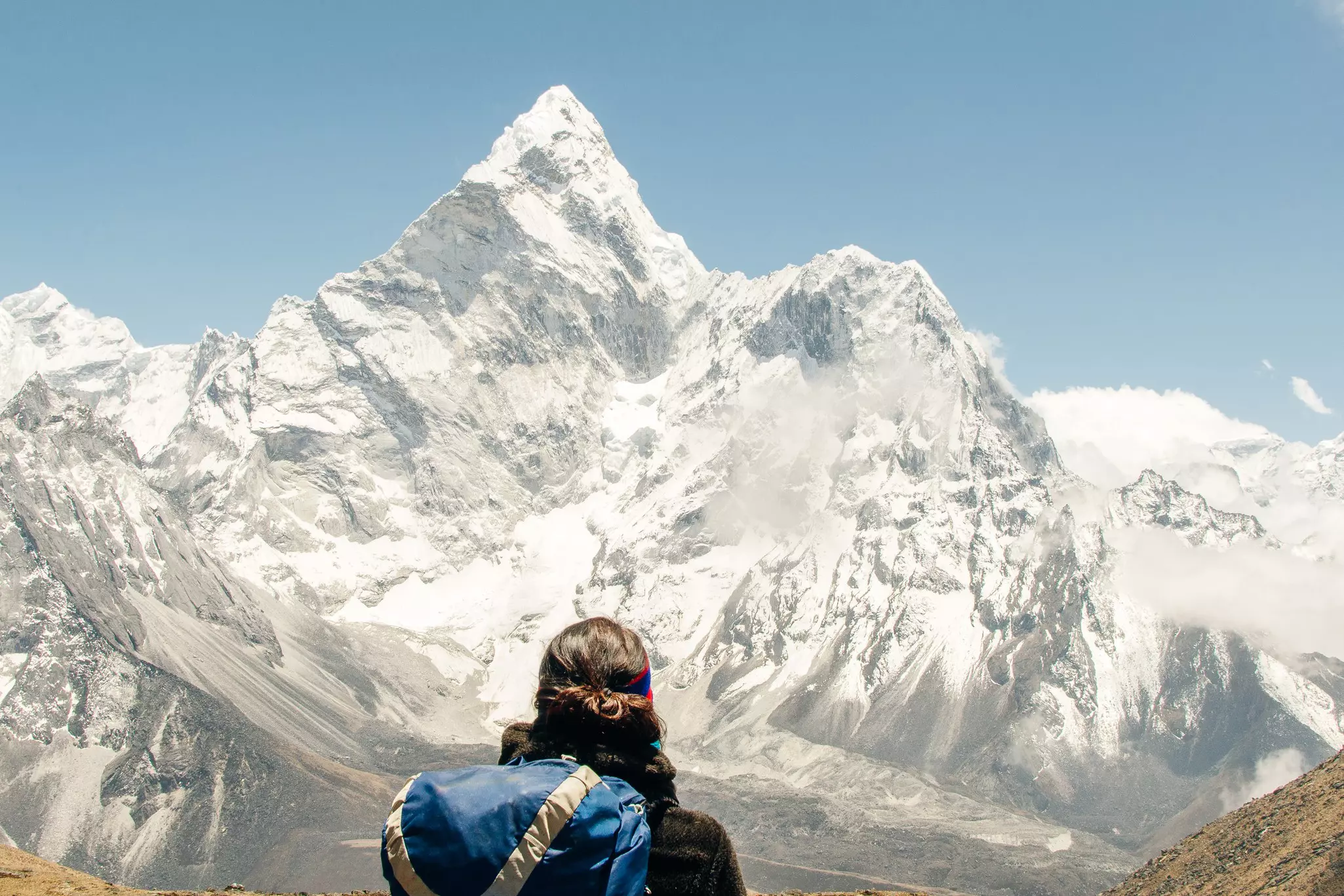 A person stands before a snowy peak in Nepal.
