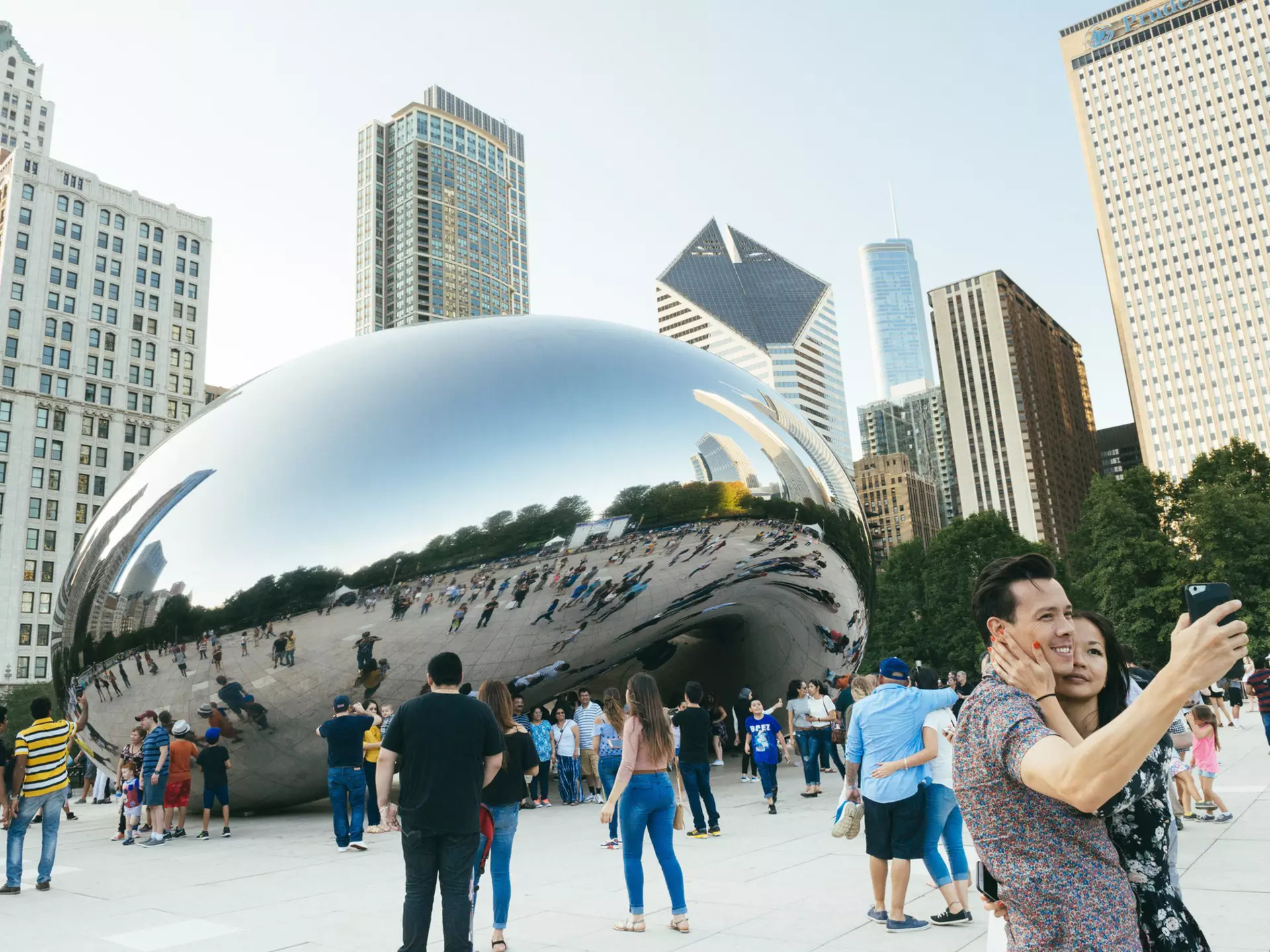 Crowds pose around the famous Cloudgate sculpture in Millennium Park